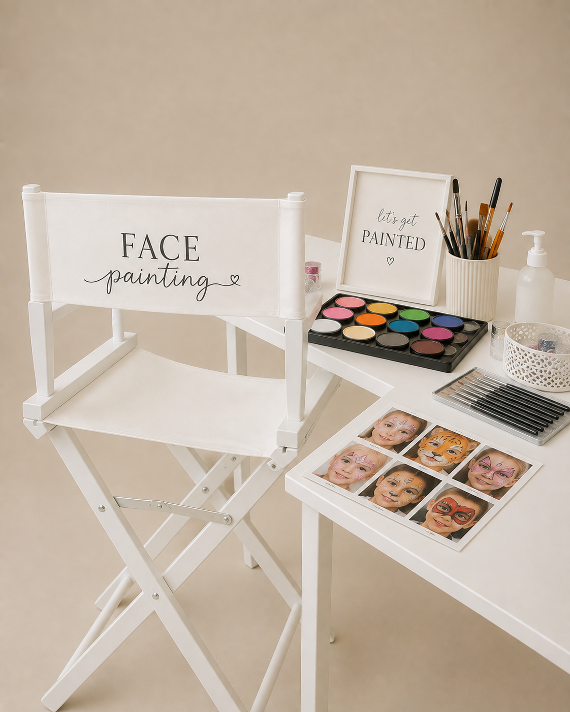 A white fabric director-style chair with 'FACE painting' printed on the back, shown beside a white table set with makeup supplies, a face paint palette, brushes, and printed face paint samples on a beige studio background.