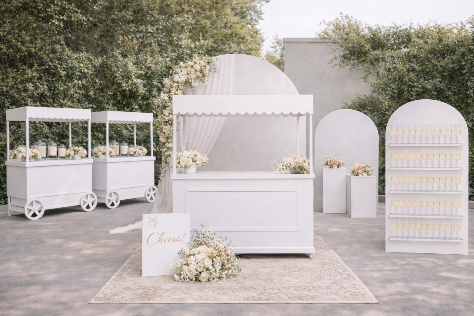 White wedding setup with floral arrangements and decorative arches outdoors.