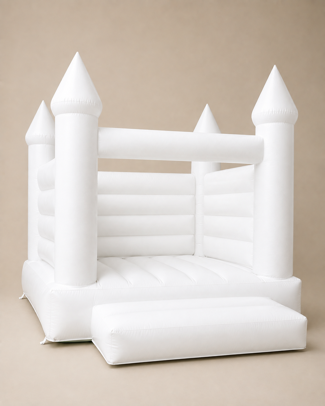 A white inflatable castle bouncy castle with four pointed turrets and a step-up entrance, shown against a solid beige background.